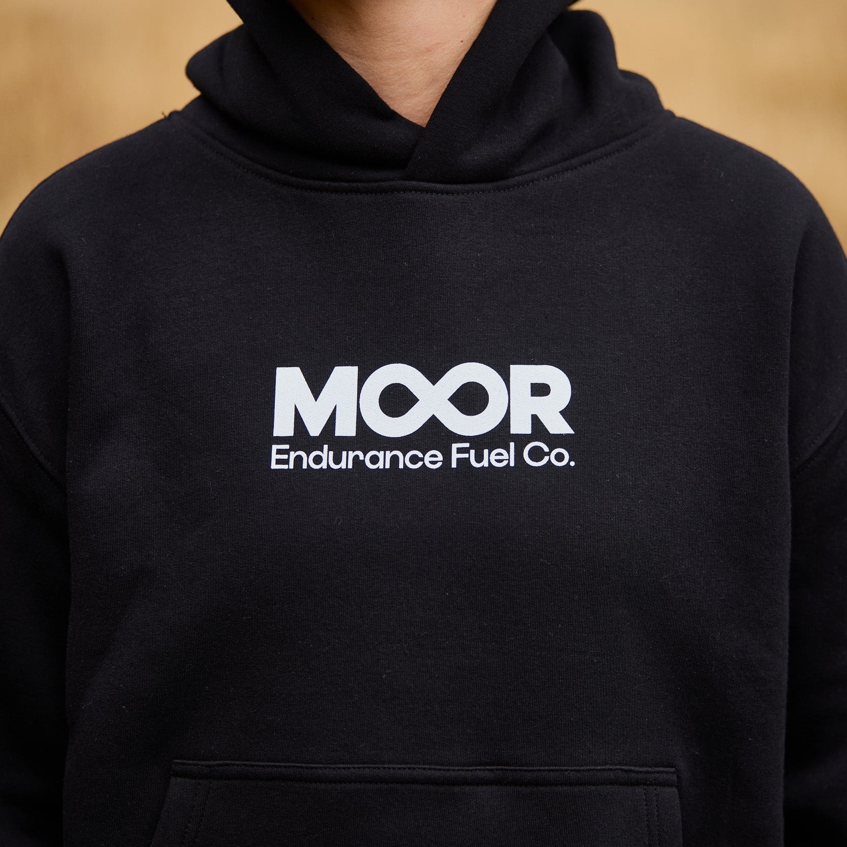 Person wearing a black hoodie with 'MOOR Endurance Fuel Co.' logo.